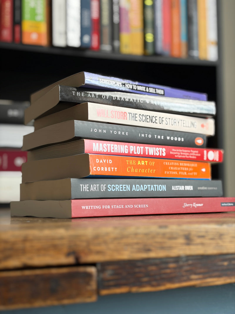 ight books for screenwriters and playwrights stacked on a wooden table